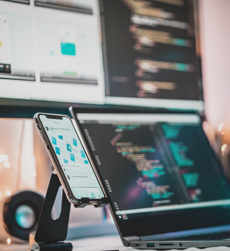 A laptop and phone on a desk for mobile development service, creating visually appealing and impactful applications for a user-centric experience.