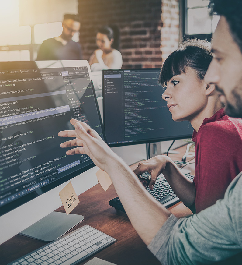 Two people coding on computer screens, ensuring efficient, speedy website with seamless navigation for enhanced user experience.