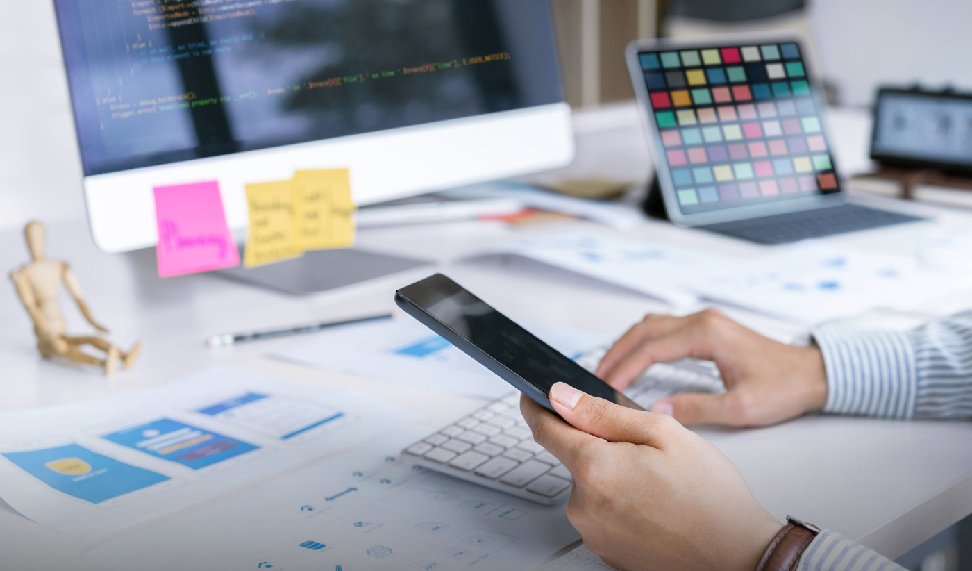 A man at his desk using a cell phone for a professional mobile development service 