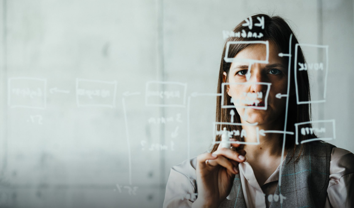 An attentive expert examining a wall diagram illustrating user flows.