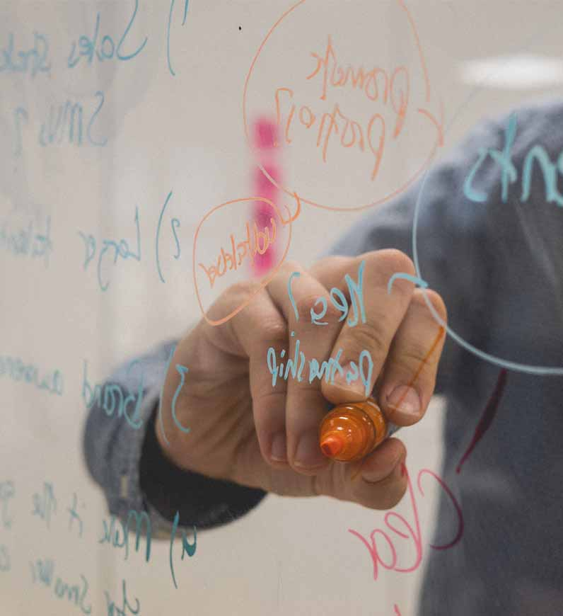  Writing on a whiteboard with markers, stressing the significance of Brand Strategy for business positioning.