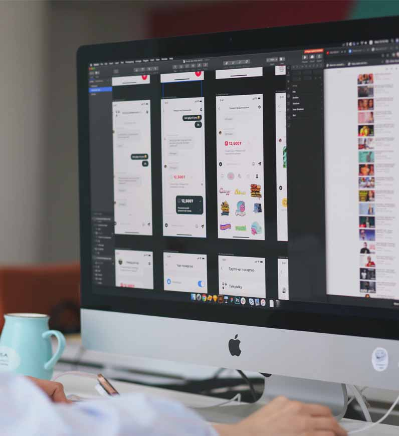 Service design work at a desk with a computer screen, focusing on customer satisfaction designs and ROI through an intuitive interface.