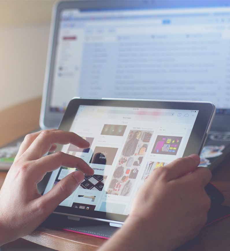 Demonstrating service design with a person using a tablet and laptop to optimize customer experiences.