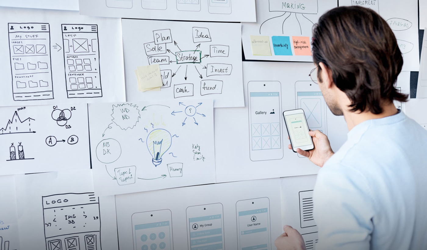 A researcher examining a whiteboard covered in notes during a UX research session to enhance the user experience